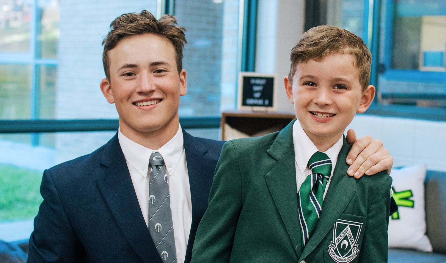 Older student teaching younger how to tie a tie